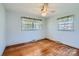 Sunlit bedroom with hardwood floors, white walls, and large windows offering scenic views at 4017 Leeds Dr, Charlotte, NC 28205