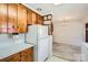 Bright kitchen featuring wood cabinets, white refrigerator, and open dining area with classic chandelier lighting at 4017 Leeds Dr, Charlotte, NC 28205