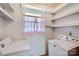 Functional laundry area features a window for natural light and shelving for storage at 4017 Leeds Dr, Charlotte, NC 28205