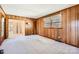 Spacious living room boasts wood paneled walls, carpet floors and view to an adjacent dining room at 4017 Leeds Dr, Charlotte, NC 28205