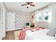 Bedroom with a floral accent wall, ceiling fan, and a cozy chair by the window at 4321 Gillespie Ct, Charlotte, NC 28205