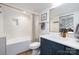 Beautifully designed bathroom featuring white tile surround and blue vanity with white marble countertop at 506 Campus St, Charlotte, NC 28216