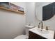 Chic half bathroom with modern vanity, gold fixtures, and stylish decorative shelving at 506 Campus St, Charlotte, NC 28216