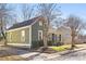 Side view of home with green siding, black roof and a well manicured yard on a sunny day at 506 Campus St, Charlotte, NC 28216