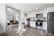 Well-lit kitchen featuring white cabinets, stainless steel appliances, and an open layout to the living area at 506 Campus St, Charlotte, NC 28216