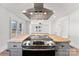 Kitchen island with gas cooktop and stainless steel hood vent with view of the living room at 601 N 12Th St, Bessemer City, NC 28016