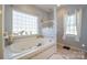 Relaxing bathroom with soaking tub, tile flooring, and large window at 6238 Mountain Vine Ave, Kannapolis, NC 28081