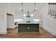 Modern kitchen with white cabinetry, dark island, stainless steel appliances, and pendant lighting at 718 Barrel Aly, Fort Mill, SC 29715