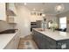 A modern kitchen features an island with seating and stainless appliances and opens into a dining area at 8125 Houser St, Cornelius, NC 28031