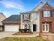 Two-story brick and beige house with a white garage door and landscaping at 8200 Suttonview Dr, Charlotte, NC 28269