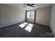 Well-lit bedroom with ceiling fan and grey carpeting at 8225 Pineville Matthews Rd # H, Charlotte, NC 28226