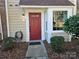 Red front door with sidelights and landscaping at 8225 Pineville Matthews Rd # H, Charlotte, NC 28226