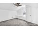 Cozy attic room with neutral carpet, a ceiling fan, a window, and built-in storage at 8228 Moores Chapel Rd, Charlotte, NC 28214