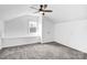 Cozy attic room with neutral carpet, a ceiling fan, a window, and built-in storage at 8228 Moores Chapel Rd, Charlotte, NC 28214