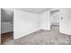 Bright attic room with gray carpet leads to a bathroom with tiled floors at 8228 Moores Chapel Rd, Charlotte, NC 28214