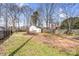 Backyard with grass, dirt, trees, privacy fence and an outbuilding at 8228 Moores Chapel Rd, Charlotte, NC 28214