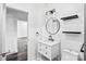 Bright bathroom features a modern vanity with drawers, a round mirror, and sleek lighting fixtures at 8228 Moores Chapel Rd, Charlotte, NC 28214