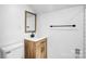 Bathroom with wood vanity, modern fixtures, white countertops and a rectangular mirror at 8228 Moores Chapel Rd, Charlotte, NC 28214