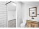 Bathroom featuring tiled shower, toilet, wood vanity with white sink and rectangular mirror at 8228 Moores Chapel Rd, Charlotte, NC 28214