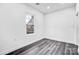 Minimalist bedroom featuring hardwood floors, a window view, and natural lighting at 8228 Moores Chapel Rd, Charlotte, NC 28214