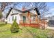 Quaint one-story home with a welcoming front porch, wooden railings, and a well-manicured lawn at 8228 Moores Chapel Rd, Charlotte, NC 28214