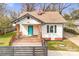 Charming single-story home featuring a wooden porch, a bright blue door, and a red brick chimney at 8228 Moores Chapel Rd, Charlotte, NC 28214