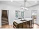 Contemporary kitchen with an island featuring a sink, modern appliances, and a clear view to stairs at 8228 Moores Chapel Rd, Charlotte, NC 28214