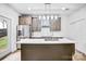 Bright kitchen with stainless steel refrigerator, island with sink, and view to the backyard at 8228 Moores Chapel Rd, Charlotte, NC 28214