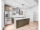 Modern kitchen features stainless steel appliances, a large island, gray cabinets, and elegant pendant lighting at 8228 Moores Chapel Rd, Charlotte, NC 28214