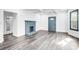 Bright living room featuring hardwood floors, a gray fireplace, and a blue door at 8228 Moores Chapel Rd, Charlotte, NC 28214