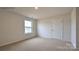 Cozy bedroom with a window, neutral walls, and carpet flooring, and a door to another room at 866 Two Brothers Ln, York, SC 29745