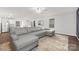 Spacious living room with gray sectional sofa and wood-look floors at 9025 Creedmore Hills Dr, Charlotte, NC 28214