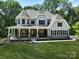 Two-story house with gray siding, stone accents, and a wrap-around porch at Lot 1 Mayes Meadow Dr # Devonshire, Cornelius, NC 28078