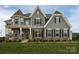 Two-story house with gray siding, stone accents, and a covered porch at Lot 1 Mayes Meadow Dr # Devonshire, Cornelius, NC 28078