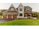 Two story house featuring stone and siding accents, a three-car garage, and a covered porch at Lot 1 Mayes Meadow Dr # Nottingham, Cornelius, NC 28078