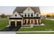 Inviting two-story home with a front porch, attached two-car garage and manicured lawn at sunset at Lot 11 Mayes Meadow Dr # Devonshire, Cornelius, NC 28078