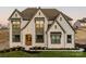 Charming two-story stone home with a manicured front yard and a welcoming wooden front door at Lot 11 Mayes Meadow Dr # Devonshire, Cornelius, NC 28078