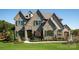 Impressive stone home with arched windows, a multi-peaked roof, and meticulously maintained landscaping at Lot 11 Mayes Meadow Dr # Devonshire, Cornelius, NC 28078
