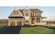 Stunning two-story home showcasing stone details, a two-car garage, and a covered front porch at Lot 11 Mayes Meadow Dr # Devonshire, Cornelius, NC 28078