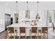 Modern kitchen featuring an island with seating and stainless steel appliances, complemented by decorative lighting at Lot 11 Mayes Meadow Dr # Devonshire, Cornelius, NC 28078