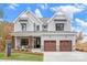 Two-story farmhouse exterior with gray siding, brown accents, and a two-car garage at Lot 113 Mayes Meadow Dr # Savanh, Cornelius, NC 28078