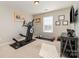 An exercise room features an elliptical machine, free weights, a mounted TV, and lots of natural light at 10149 Elizabeth Crest Ln, Charlotte, NC 28277