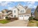 Two-story home featuring neutral siding, a three-car garage, manicured landscaping, and a well-maintained lawn at 10149 Elizabeth Crest Ln, Charlotte, NC 28277