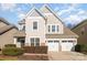 Two-story home featuring neutral siding, a three-car garage, manicured landscaping, and a well-maintained lawn at 10149 Elizabeth Crest Ln, Charlotte, NC 28277