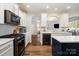 Well-designed kitchen features stainless steel appliances, tile backsplash, and white cabinetry at 10149 Elizabeth Crest Ln, Charlotte, NC 28277