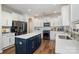 Bright kitchen features a navy island with white countertops, stainless steel appliances, and wood flooring at 10149 Elizabeth Crest Ln, Charlotte, NC 28277