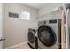 The laundry room has a washer, dryer, a window with blinds and a shelf for storage at 10149 Elizabeth Crest Ln, Charlotte, NC 28277