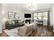 Living room features hardwood floors, a fireplace, modern décor, and a large window with natural light at 10149 Elizabeth Crest Ln, Charlotte, NC 28277