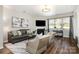 Living room features hardwood floors, a fireplace, modern décor, and a large window with natural light at 10149 Elizabeth Crest Ln, Charlotte, NC 28277