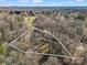 Aerial view of the property marked with an approximate boundary line in a wooded area near other homes at 108 Three Oaks Ln, Kings Mountain, NC 28086